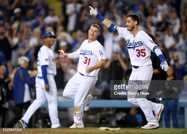 Cody Bellinger of the Los Angeles Dodgers celebrates his walk off solo homerun in front of Joc Pederson and third base coach Dino Ebel, for a 5-4 win...