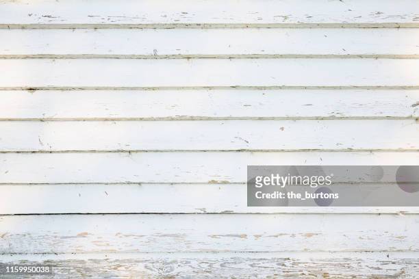 full frame shot of white painted, weathered wooden wall with shadow and sunlight - holzwand shabby chic stock-fotos und bilder