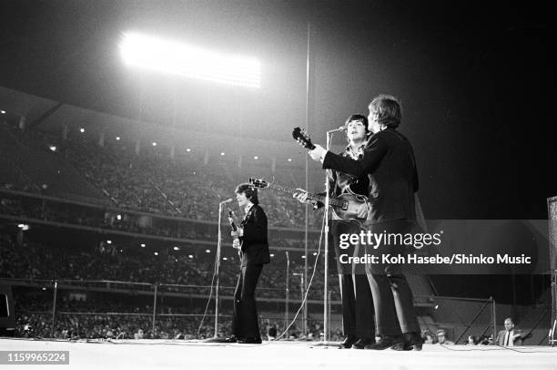 George Harrison, Paul McCartney and John Lennon of The Beatles perform on stage at the Dodger Stadium, Los Angeles, California, United States on the...