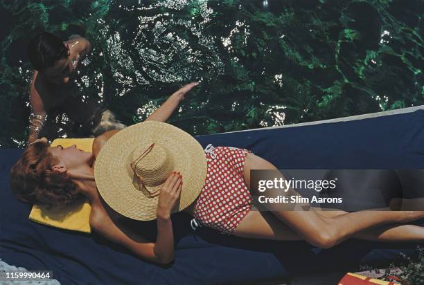 Lillian Hanson relaxes by the swimming pool at the Burgenstock Estate, Lake Lucerne, Switzerland, 1955.