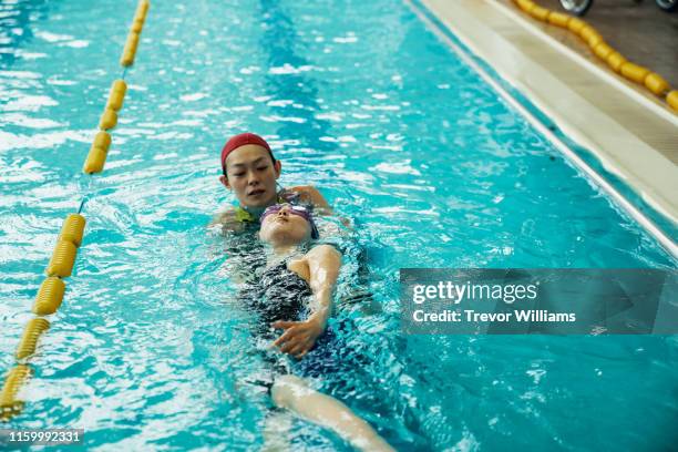 swimming coach working with a disabled woman who is training for competition - swimming coach stock pictures, royalty-free photos & images