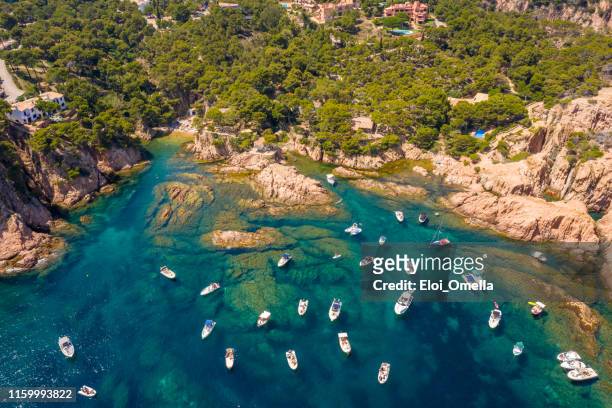 luchtfoto van aigua xelida beach bay met boten in begur, costa brava, spanje - catalogne stockfoto's en -beelden