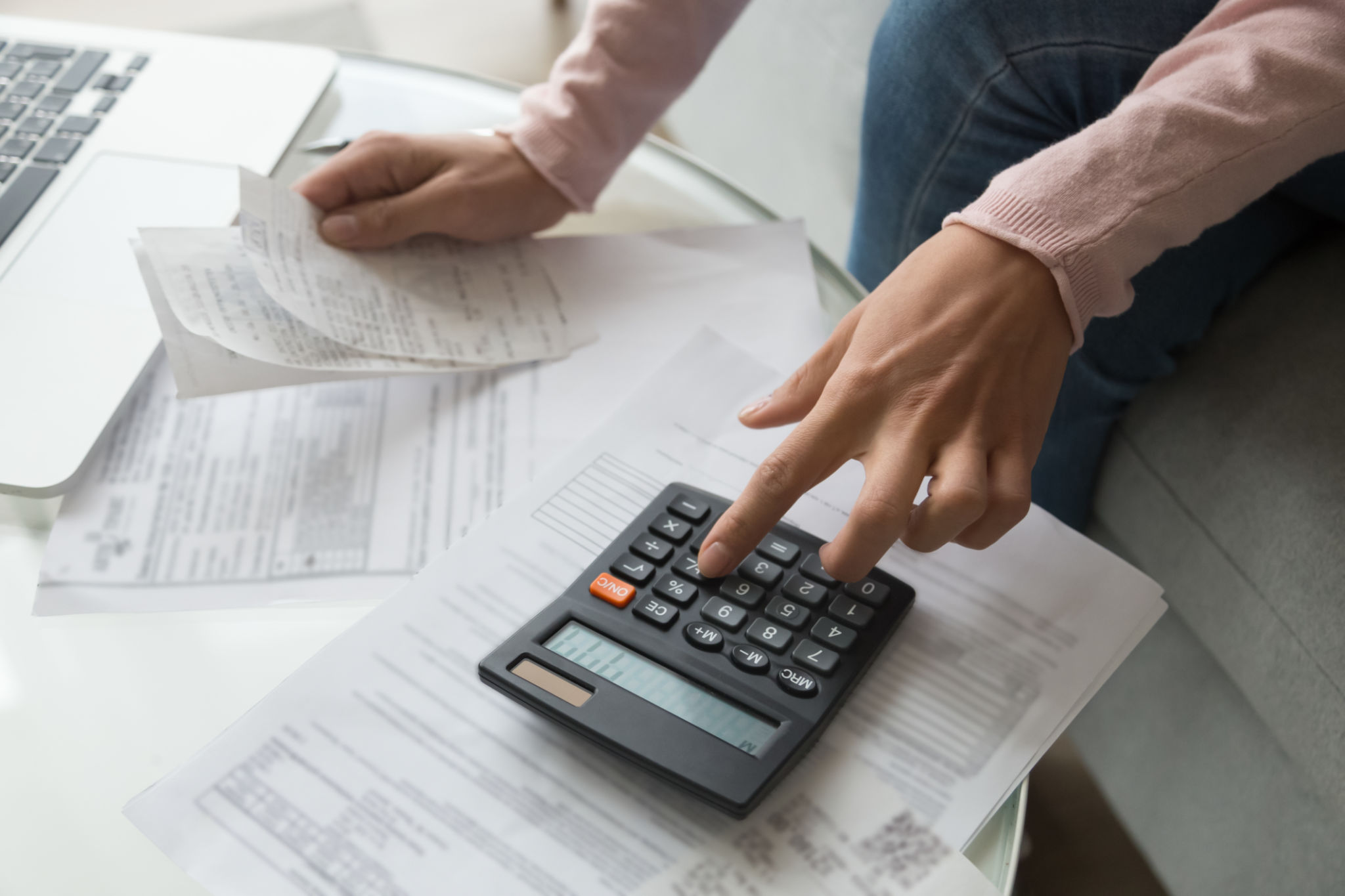 Close up woman hands holding receipt calculating company expenses Close up woman hands holding receipt calculating company expenses