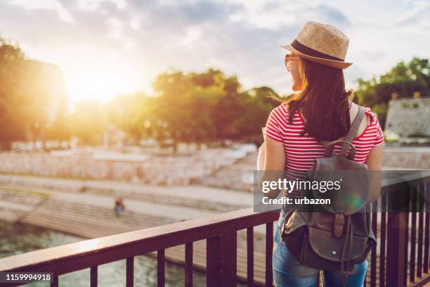 young woman exploring city - looking over fence stock pictures, royalty-free photos & images