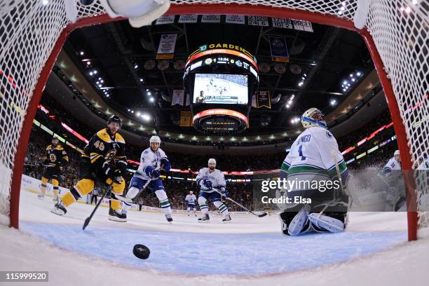 David Krejci stands by the net as Milan Lucic , #17 of the Boston Bruins scores a goal in the first period against Roberto Luongo of the Vancouver...