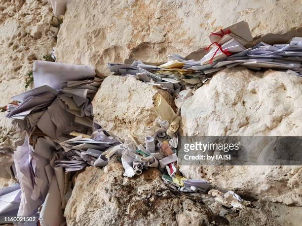 close-up of the western/ wailing wall with lots of prayer notes placed in the crevices, full frame - wailing wall stock pictures, royalty-free photos & images