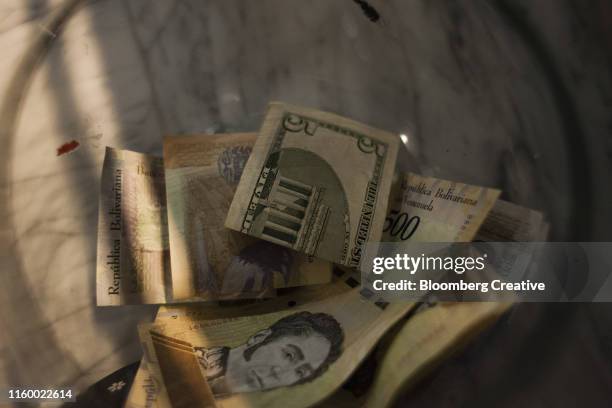 u.s. dollar and venezuelan bolivar banknotes - bolívar venezolano divisa fotografías e imágenes de stock