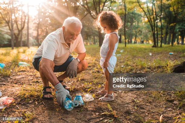 grandfather and granddaughter recycling - biodegradable plastic stock pictures, royalty-free photos & images