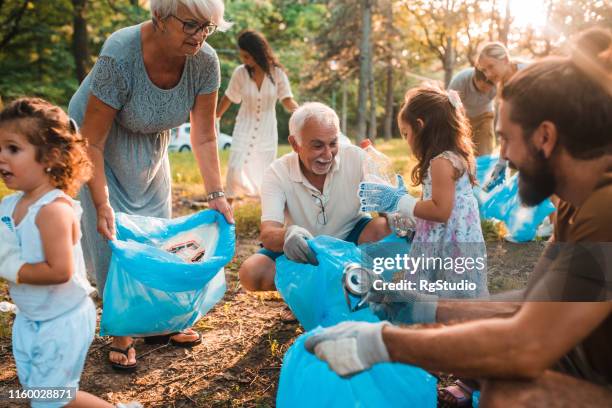 glückliche familie mit kindern recycling - father and children volunteering stock-fotos und bilder