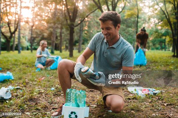 ijverig jonge man recycling - glasbak stockfoto's en -beelden