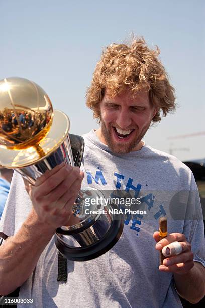 Dirk Nowitzki of the Dallas Mavericks shows off his Bill Russell NBA Finals MVP trophy as the Mavs are greeted by thousands of fans after winning the...