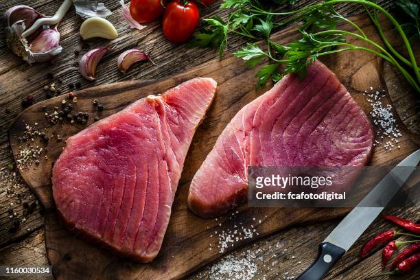 dos filetes de atún crudo sobre mesa de madera rústica - raw fish fotografías e imágenes de stock