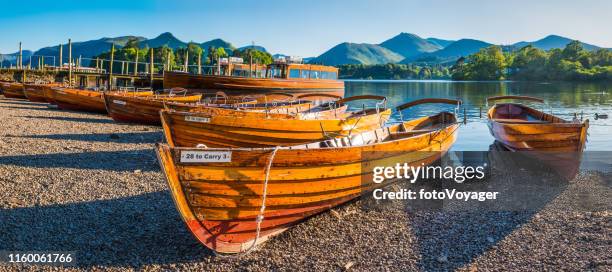 lake district wooden rowing boats derwent water below mountains panorama - keswick stock pictures, royalty-free photos & images