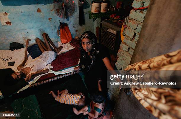 Robina, wife of Resuti a tuberculosis patient being treated by operation ASHA , looks out of their door as their children Ayan, 3 months old , and...