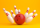 Red Bowling Ball and scattered white skittles isolated on yellow background