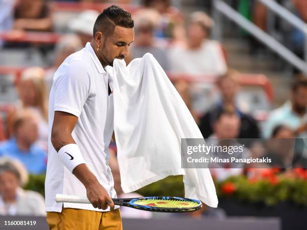 Nick Kyrgios of Australia holds his towel in his mouth against Kyle Edmund of Great Britain during day 5 of the Rogers Cup at IGA Stadium on August...