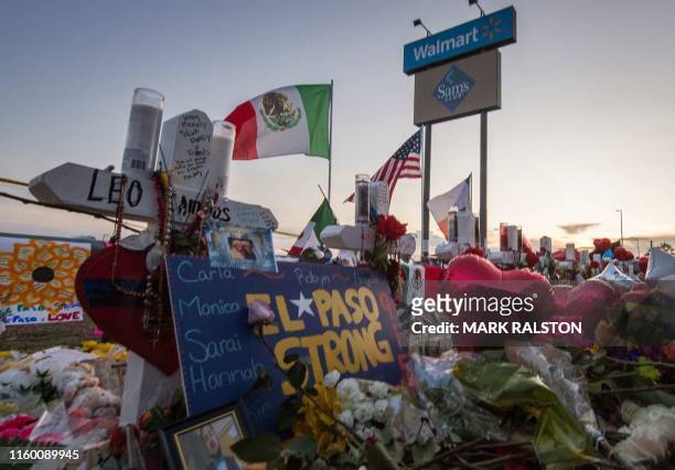 People pray and pay their respects at the makeshift memorial for victims of the shooting that left a total of 22 people dead at the Cielo Vista Mall...
