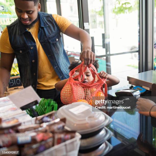 customers shopping in small zero waste oriented fruit and grocery store. - reusable bag stock pictures, royalty-free photos & images