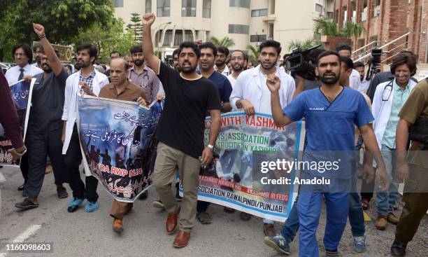 Young Pakistani doctors, paramedics and nurses chant anti-India slogans as they take part in a protest to condemn the Indian government decision to...