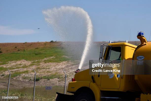 Water is sprayed onto grass from a truck near Ted Stevens Anchorage International Airport on July 4, 2019 in Anchorage, Alaska. Alaska is bracing for...