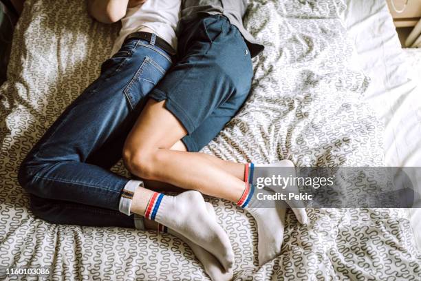 homosexual partners sleeping in bed together - spooning stock pictures, royalty-free photos & images