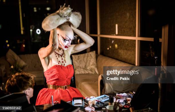 drag queen putting blond wig - burlesque stock pictures, royalty-free photos & images