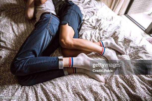 partner omosessuali che dormono a letto insieme - gay couple sleeping in bed foto e immagini stock
