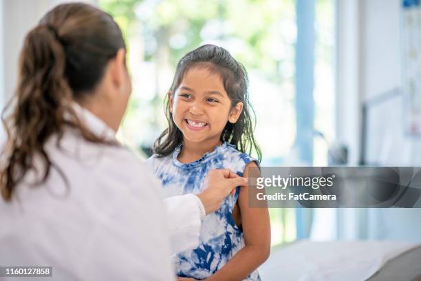 cute little girl at doctor's office - hispanic medical exam stock pictures, royalty-free photos & images