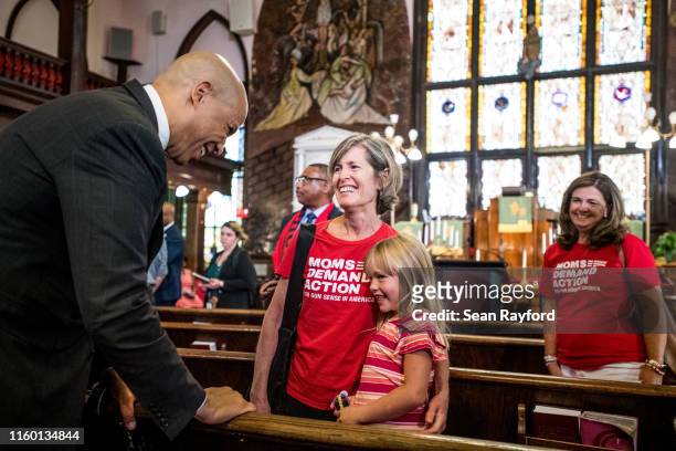 Democratic presidential candidate and U.S. Sen. Cory Booker talks with a young girl and Leslie Armstrong, with Moms Demand Action, after speaking to...