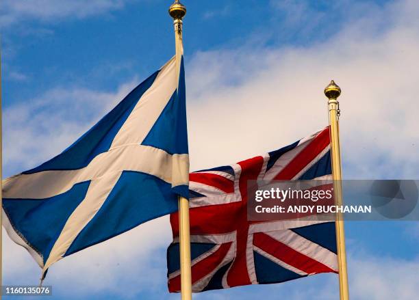 The Scottish Saltire and the Union Flag flutter above Stirling Castle in the historic town of Stirling, central Scotland on August 7, 2019.