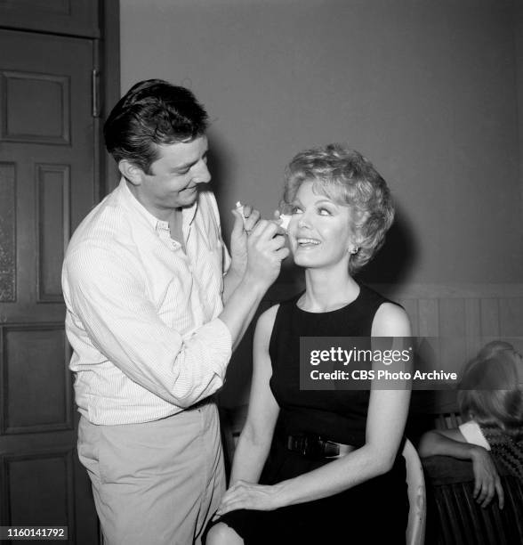 Makeup artist John Jiras is photographed behind the scenes with star Joanna Barnes on the set of the CBS television legal drama, "The Trials of...