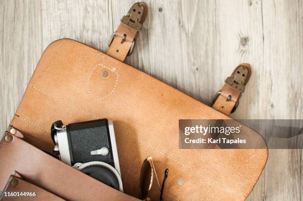 travel concept flat lay of men's leather bag, camera and sunglasses - camera bag stockfoto's en -beelden