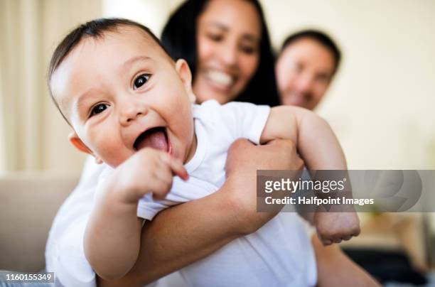 affectionate young couple in love with a baby at home, resting. - baby stock-fotos und bilder