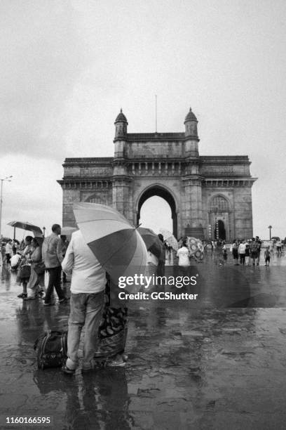 tourists visiting gateway of india on a rainy day, mumbai - mumbai rain stock pictures, royalty-free photos & images