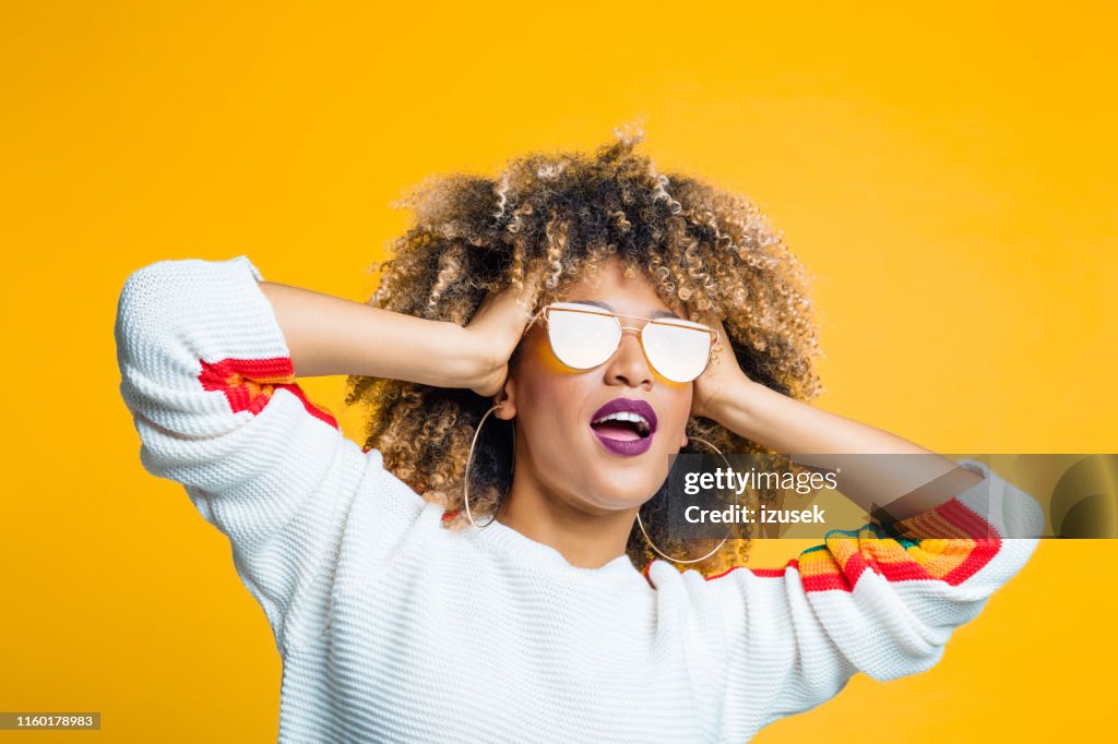 Funky Afro meisje tegen gele achtergrond