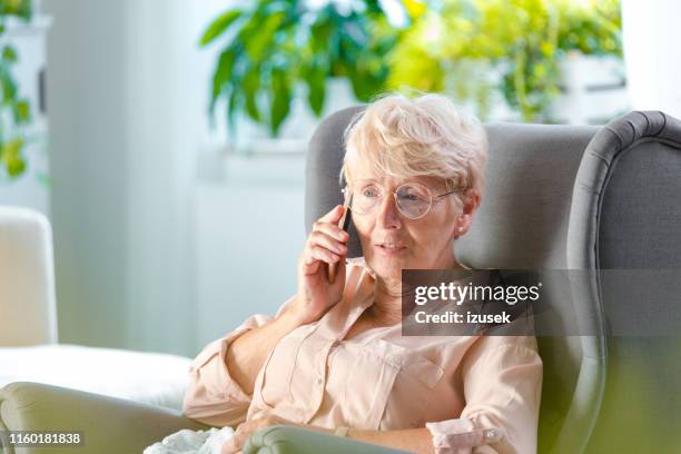 senior woman talking on mobile phone - female worried mobile imagens e fotografias de stock