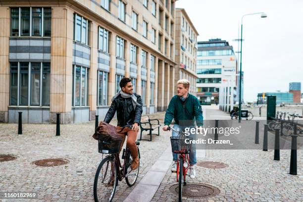 gay couple riding bicycles - malmo sweden stock pictures, royalty-free photos & images