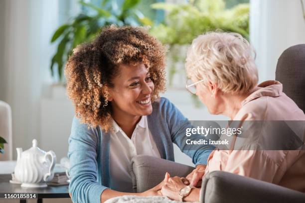 home caregiver taking care of elderly woman - caring for elderly stock pictures, royalty-free photos & images