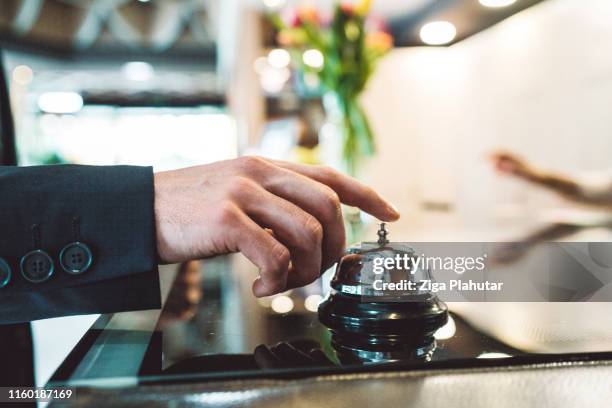 a man ringing the reception bell - travel service stock pictures, royalty-free photos & images