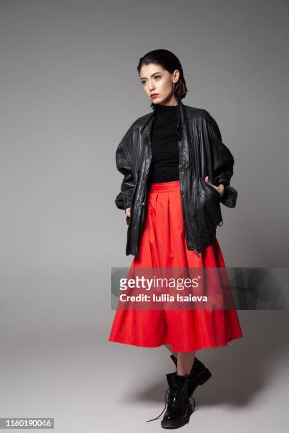 fashionable young woman standing with black jacket in studio - black boot bildbanksfoton och bilder
