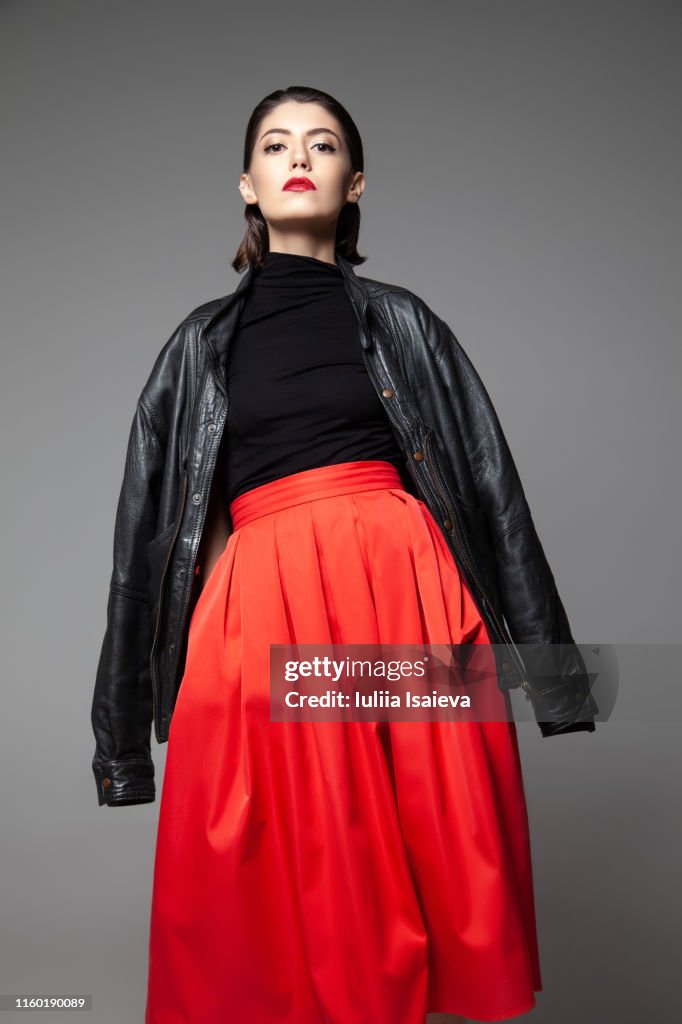 Graceful young woman wearing black jacket in studio