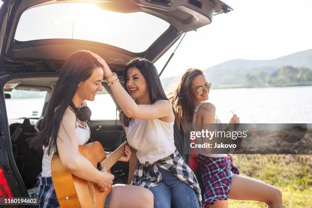 young women, on a road trip, having fun in the nature - drinking soda in car stock pictures, royalty-free photos & images