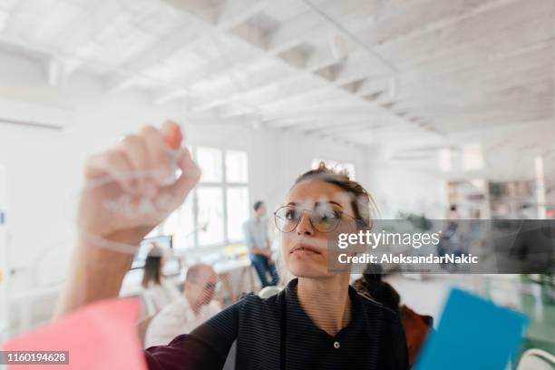 making plans on a transparent wipe board - researchers stock pictures, royalty-free photos & images