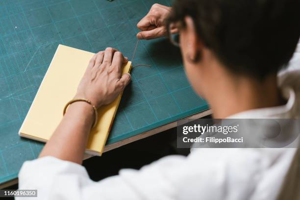 young adult woman making a notebook - book binding stock pictures, royalty-free photos & images