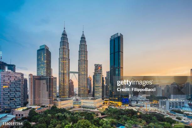 kuala lumpur skyline with petronas towers at sunset - malaysia city stock pictures, royalty-free photos & images