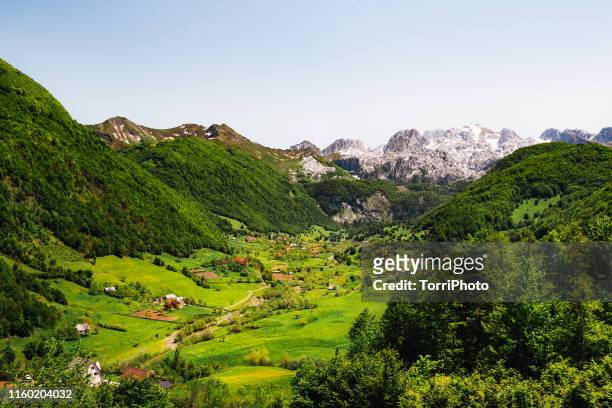village in the valley among the mountains - albanië stockfoto's en -beelden
