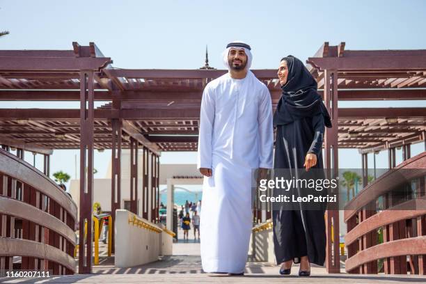traditional arab couple in love out for a walk in the public park - emirati enjoy stock pictures, royalty-free photos & images