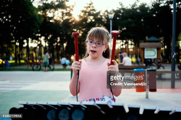 elementary alter kleines mädchen spielen im park - xylophone stock-fotos und bilder