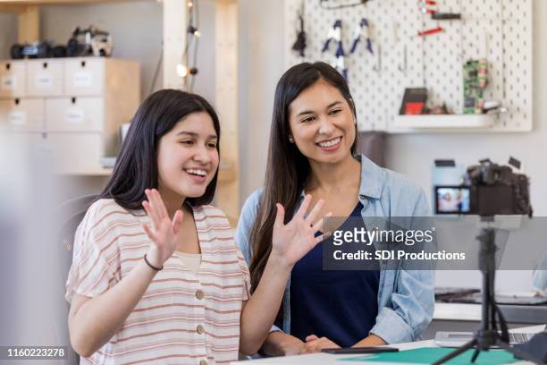 teen waves to camera as mom smiles - indian aunt stock pictures, royalty-free photos & images