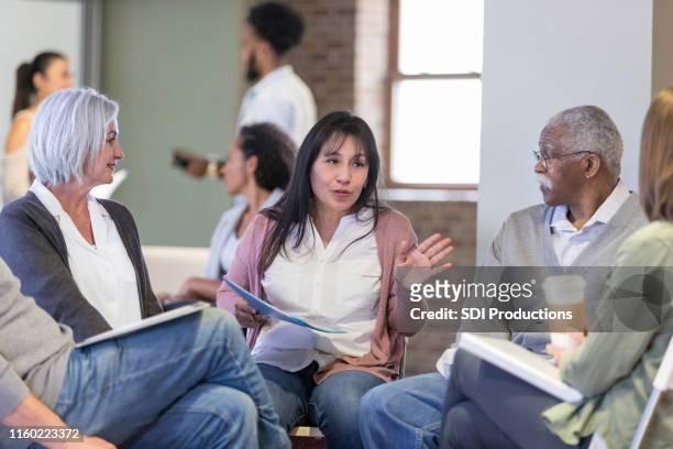 woman discusses neighborhood issues during hoa meeting - community meeting stock pictures, royalty-free photos & images